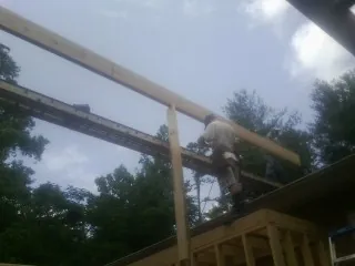 Carpenter setting a ridge beam over a new addition frame — Ice Dam Removal by Roofing Brothers in Foxburg