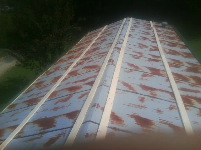 Rusted metal roof panels with new wood purlins before replacement in Foxburg