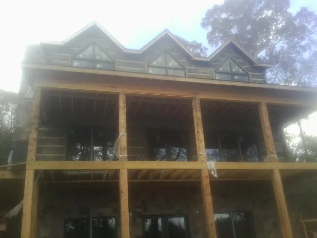 Dormers and porch framing on a large log home under construction — Roof Coating work by our crew in Foxburg